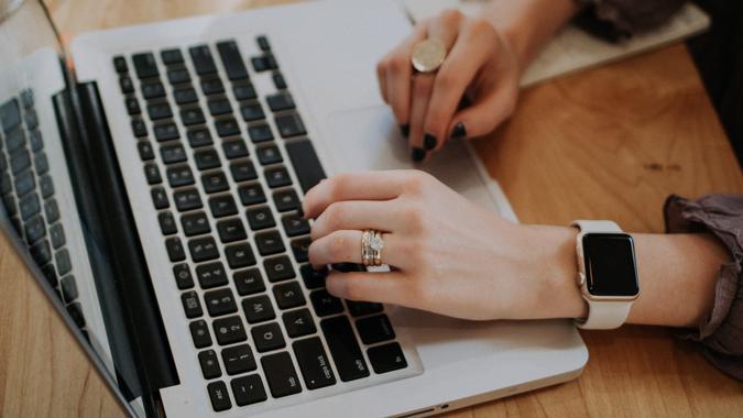 woman typing password on laptop woman typing password on laptop
