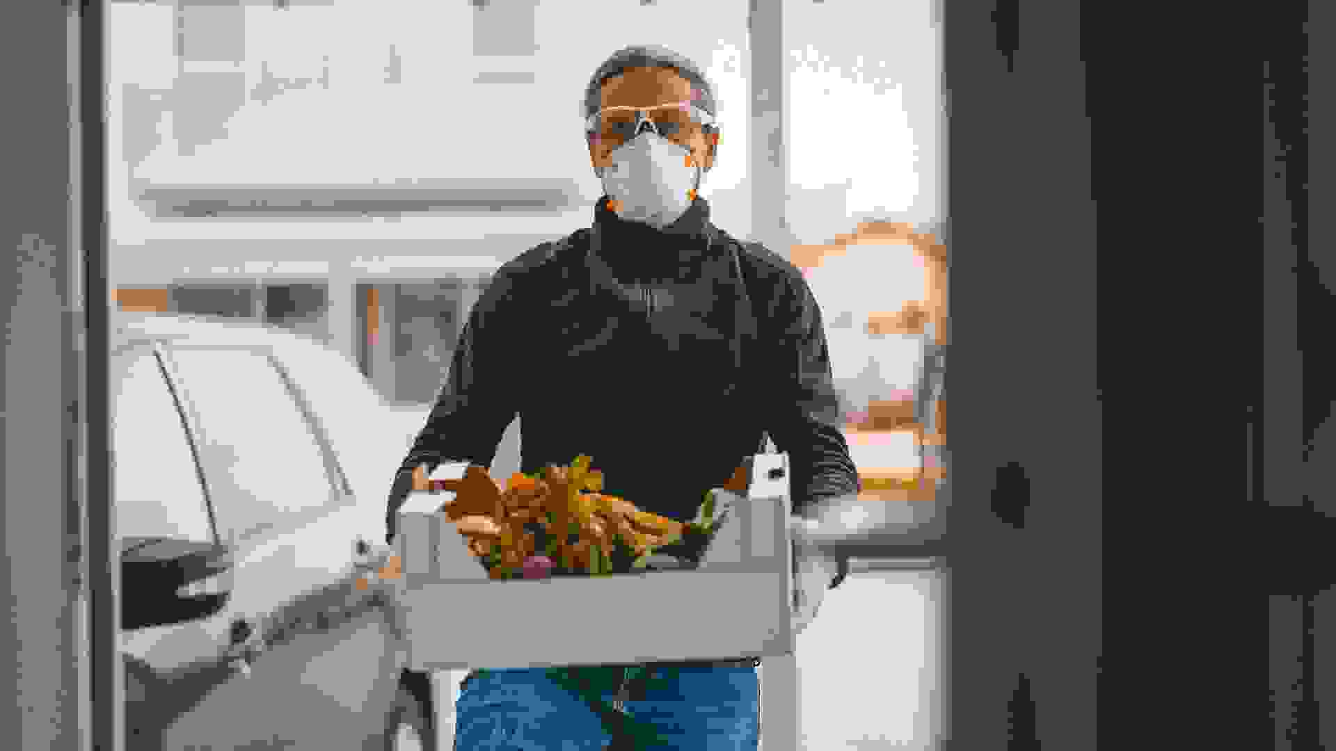 woman with covid-19 mask with groceries