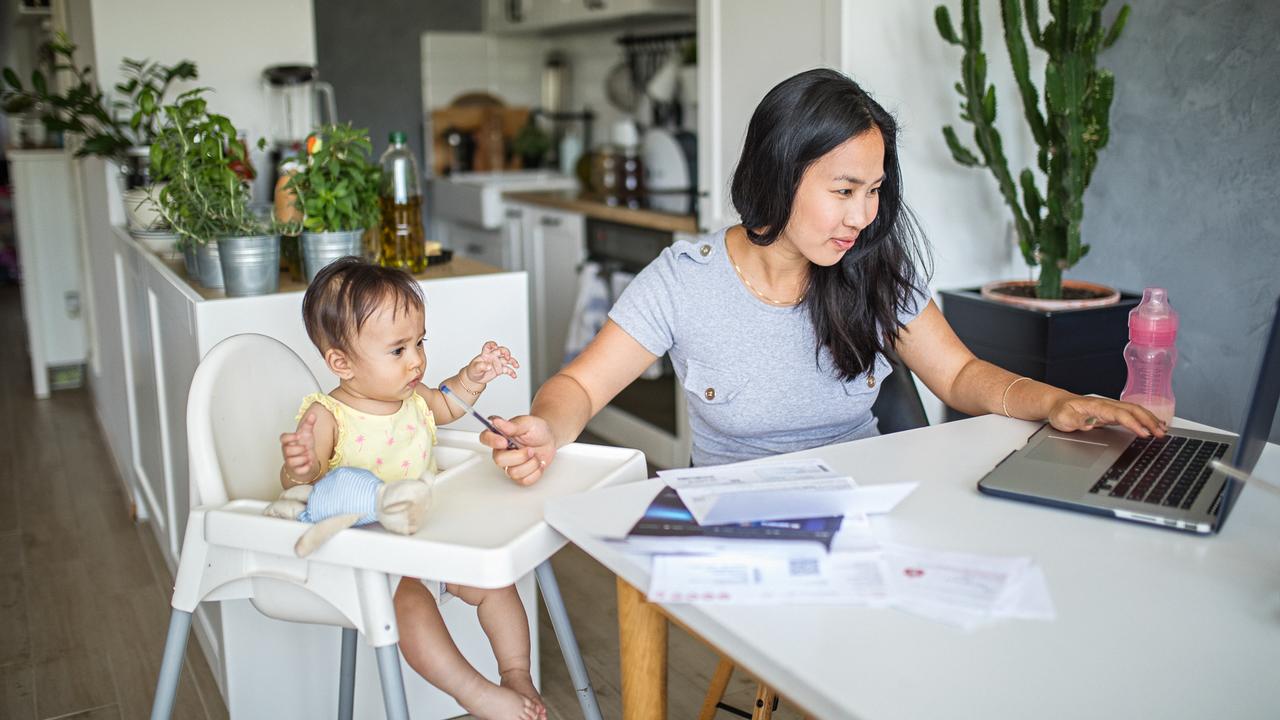 Young Asian mother working and spending time with baby at home.