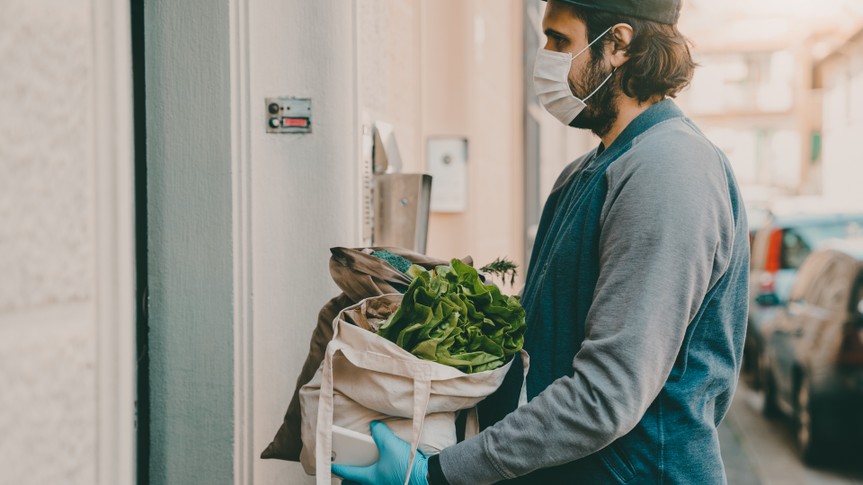 A man is delivering a bag of vegetables and fruit.