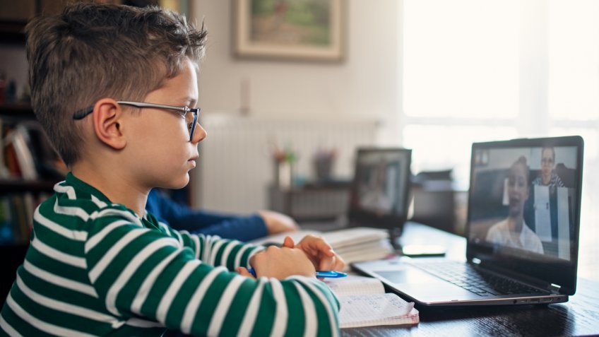 Little boys attending to online class from home.