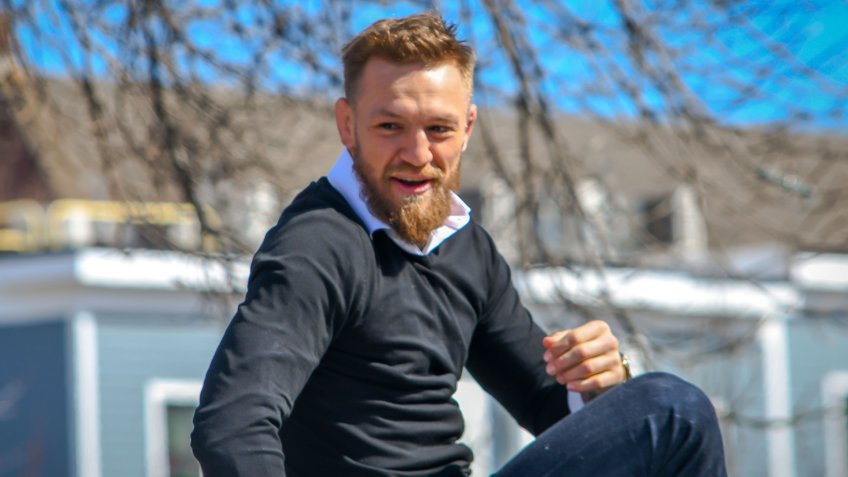 South Boston, MA - 3/17/19: MMA fighter Conor McGregor rides atop a car in the St Patrick's Day Parade.