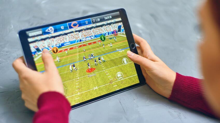 Bishkek, Kyrgyzstan - January 21, 2019: Girl playing a mobile game madden nfl of ea sports company on ipad pro.