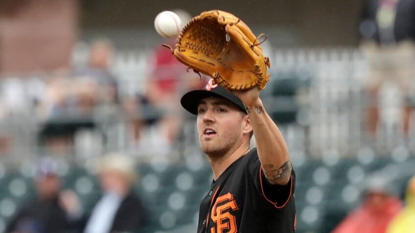 Mandatory Credit: Photo by Elaine Thompson/AP/Shutterstock (10580485o)San Francisco Giants starting pitcher Kevin Gausman reaches for the ball against the Texas Rangers during a spring training baseball game, in Surprise, ArizGiants Rangers Spring Baseball, Surprise, United States - 11 Mar 2020.