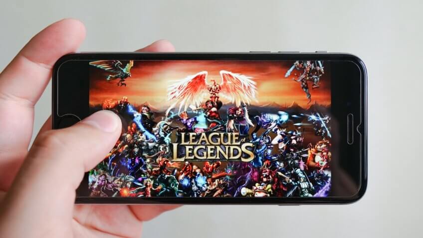 Los Angeles, California, USA - 9 June 2019: Hands holding a smartphone with League of Legends game on display screen, Illustrative Editorial.