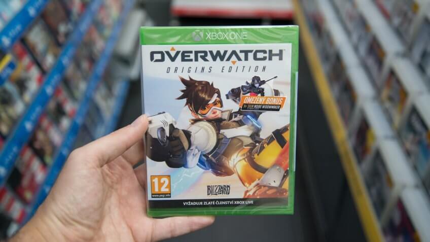 Bratislava, Slovakia, circa april 2017: Man holding Overwatch videogame on Microsoft XBOX One console in store.