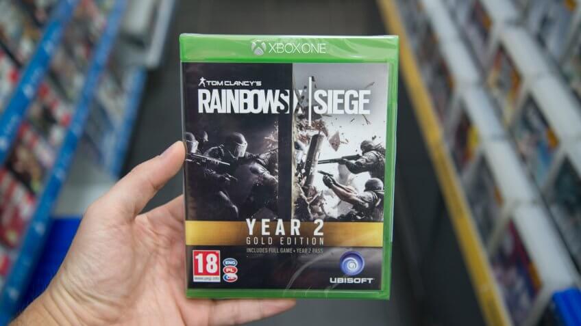 Bratislava, Slovakia, circa april 2017: Man holding Tom Clancy's Rainbow Six: Siege Gold Edition Year 2 videogame on Microsoft XBOX One console in store.