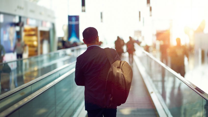 rear view of Asian businessman walking in departure area of Shenzhen airport, China.