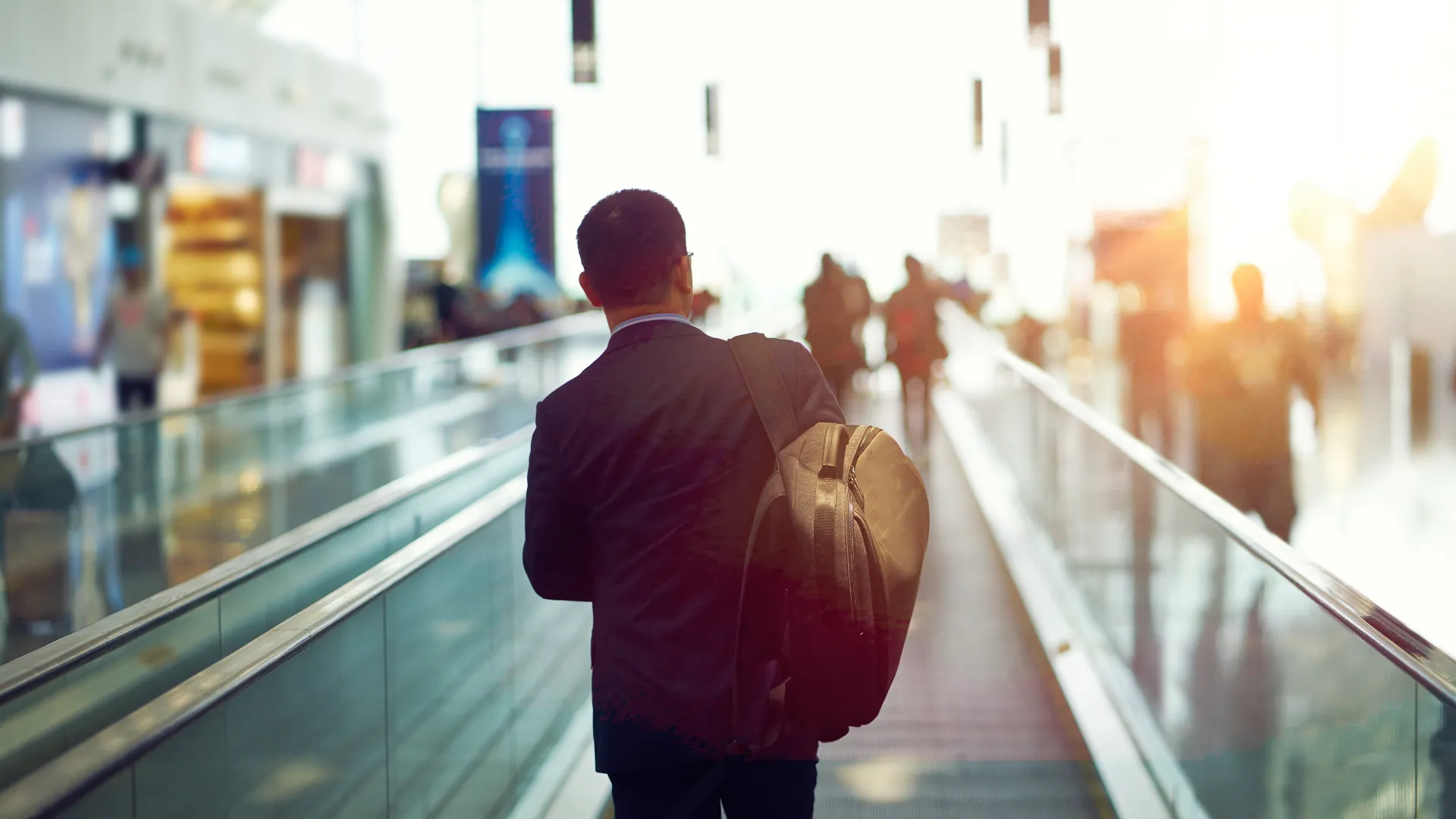 rear view of Asian businessman walking in departure area of Shenzhen airport, China.