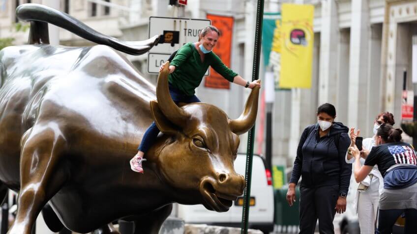 Mandatory Credit: Photo by William Volcov/Shutterstock (10651162c)People fail to maintain social distancing as they pose with the Charging Bull statue on Wall Street during the Coronavirus outbreakCoronavirus outbreak, New York, USA - 18 May 2020.