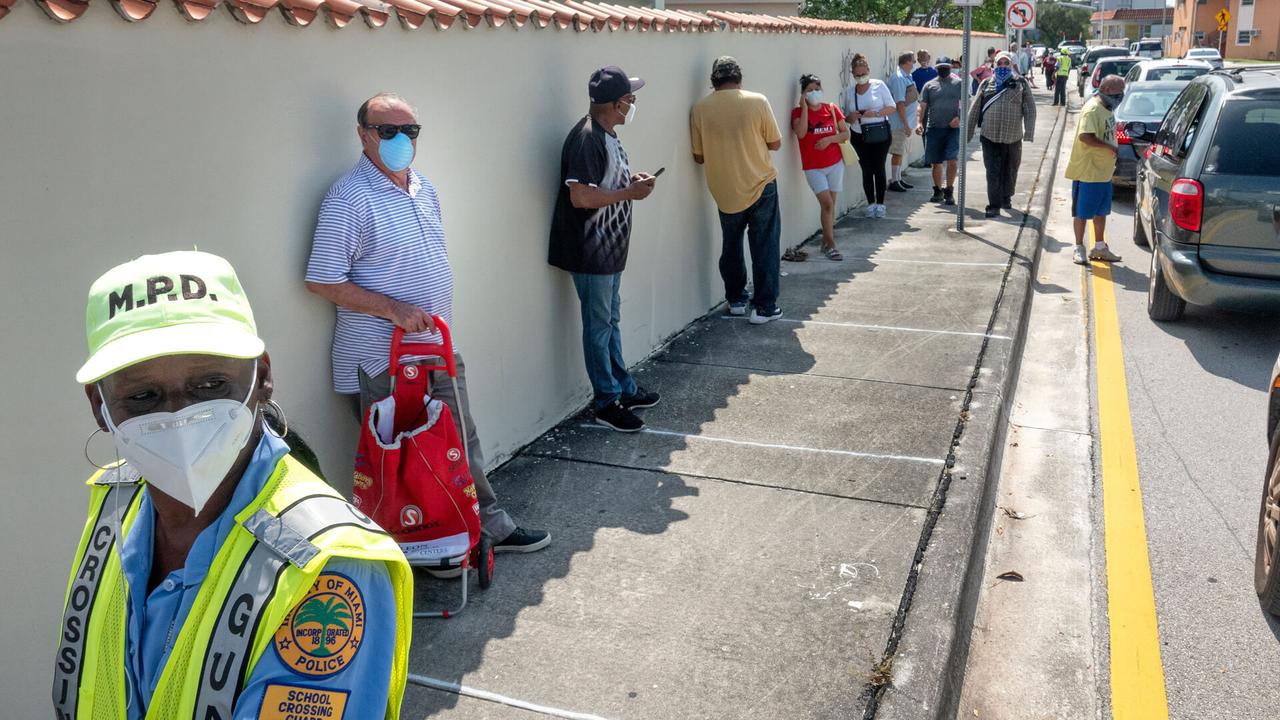 Mandatory Credit: Photo by CRISTOBAL HERRERA/EPA-EFE/Shutterstock (10652015a)A Miami Police officer guards the line of the people who are going to receive bags of hot food, cooked in local restaurants, in Little Havana, Miami, Florida, USA, 19 May 2020.