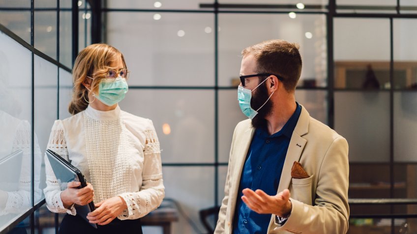 Businesspeople wearing masks in the office for safety during epidemic situation.