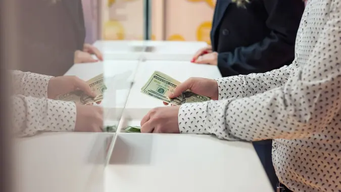Male hand with money at cash desk.