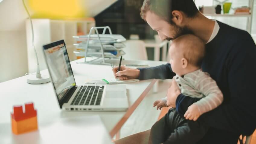 Little baby boy is spending time in his dad's office.