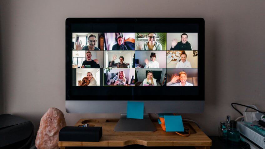 Image of a team conference call on a computer screen in a home office.