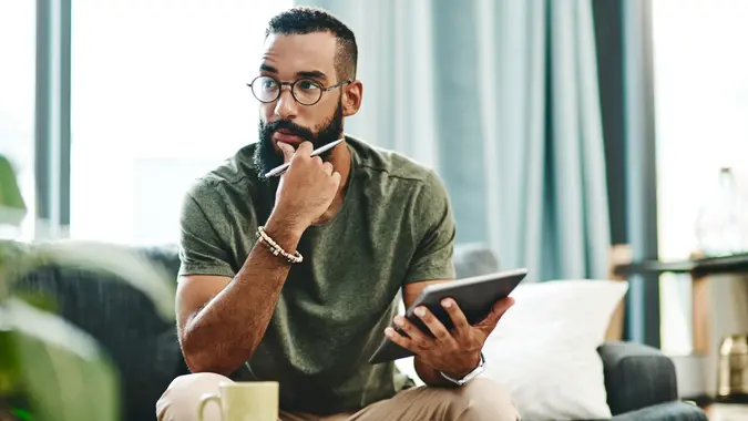 Shot of a young man going over his finances at home.