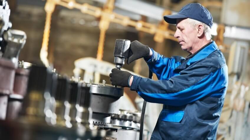 adult experienced industrial worker during heavy industry machinery assembling on production line manufacturing workshopClick on banner below to view more images in the.