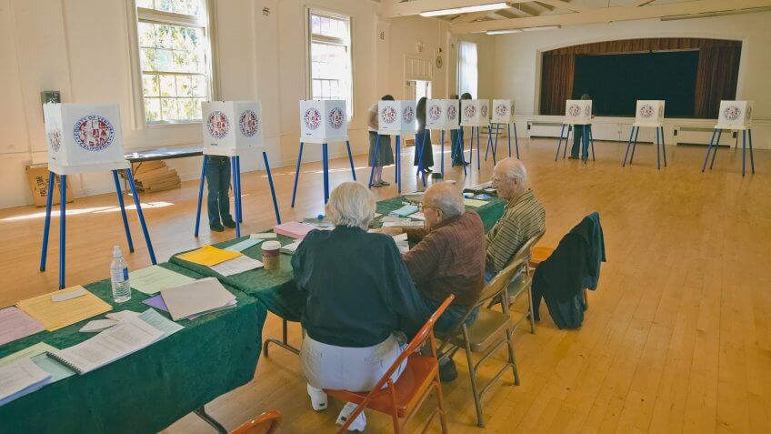 Election volunteers and voting booths in a polling place, CA.
