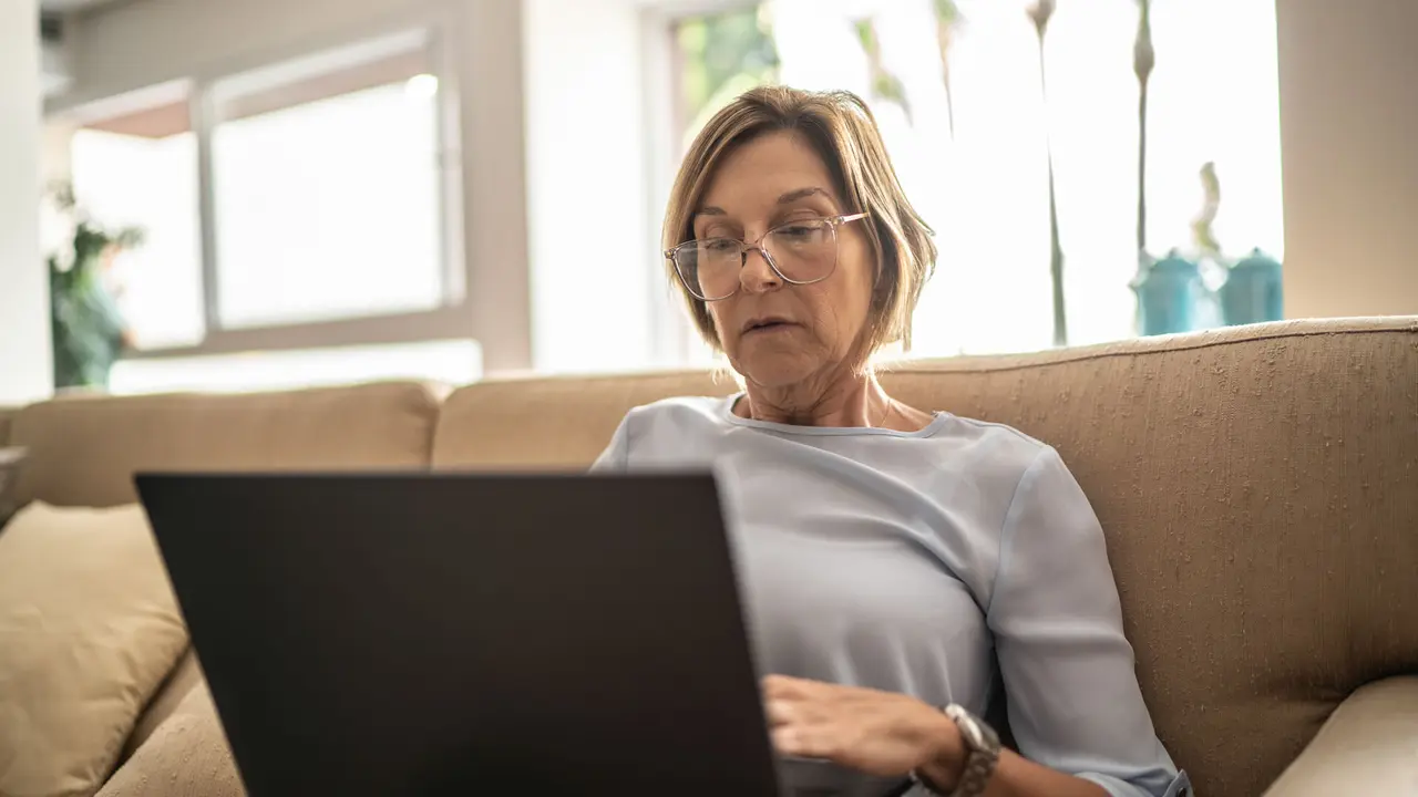 Mature woman using laptop in the living room.