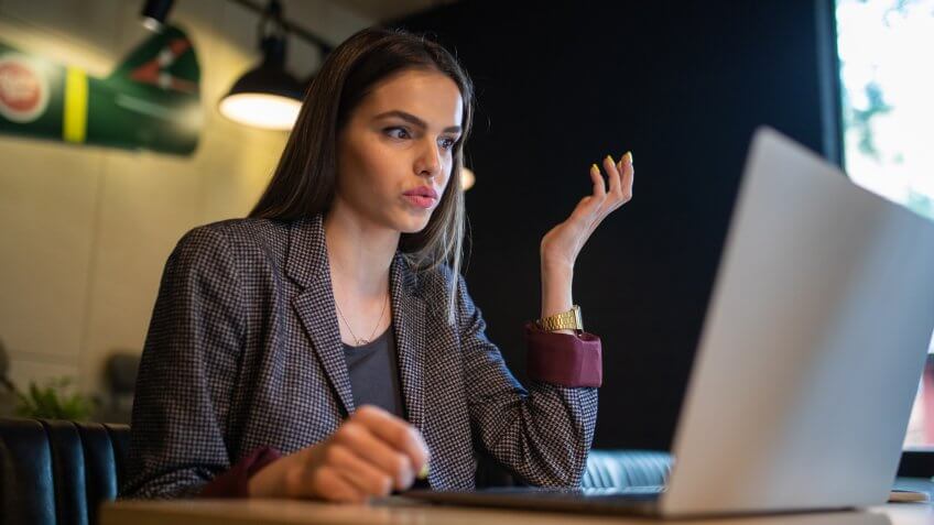 Businesswoman doing her tiresome work while sitting in her local cafe.