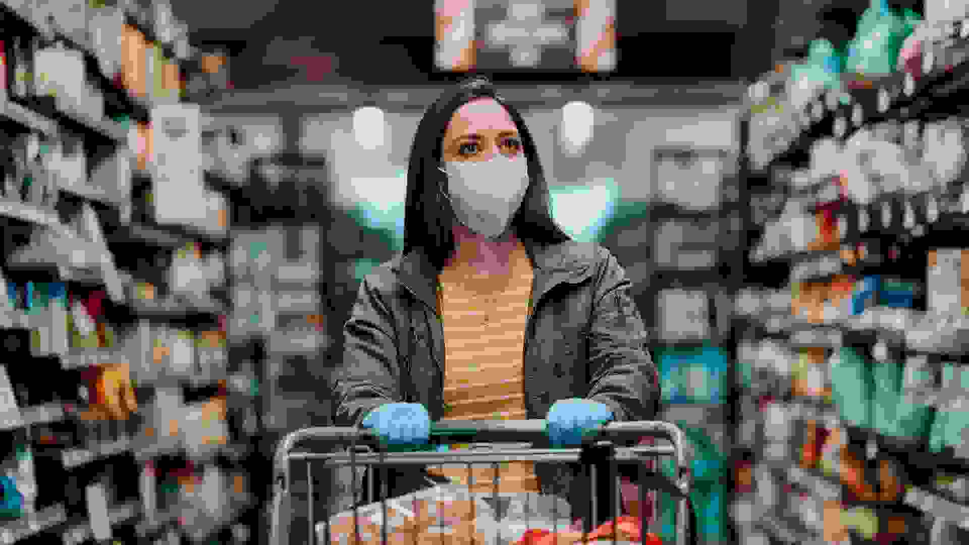 Woman pushing supermarket cart during COVID-19.