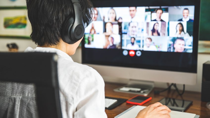 Woman working at home having a video conference with colleagues.