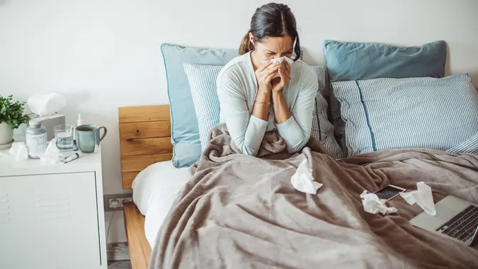 Woman with flu in bed, she use home medicine to handle sickness.