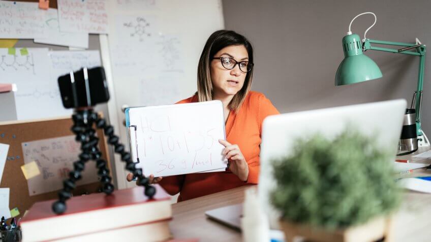 Experienced teacher or professor explaining chemistry or other science over internet to students.