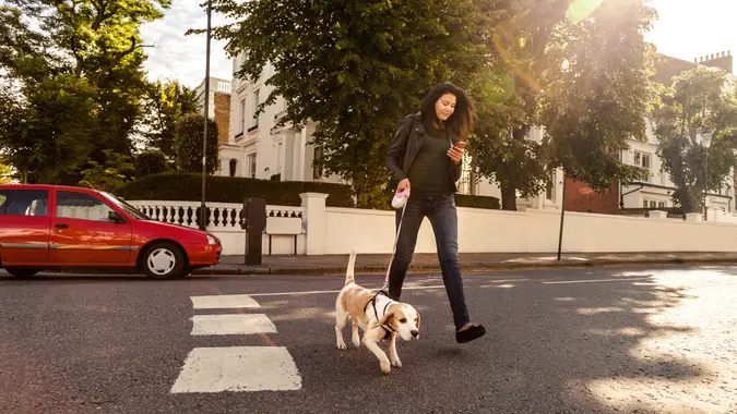 Happy woman walking with dog in early Sunday morning in London, Notting Hill.