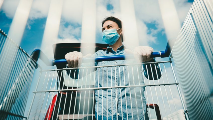 woman wearing mask pushing shopping cart