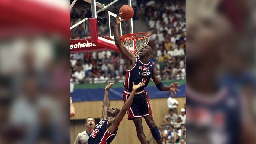 USA's Michael Jordan sails high above teammate Magic Johnson knocking away a shot during the first half of their preliminary round basketball game with Croatia at the Summer Olympics in Barcelona.