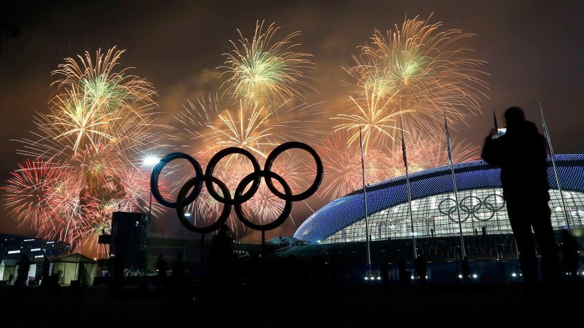 A man takes a photograph of fireworks during the closing ceremony of the 2014 Winter Olympics, in Sochi, Russia.