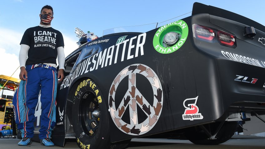 MARTINSVILLE, VIRGINIA - JUNE 10: Bubba Wallace, driver of the #43 Richard Petty Motorsports Chevrolet, wears a "I Can't Breathe - Black Lives Matter" t-shirt under his fire suit in solidarity with protesters around the world taking to the streets after the death of George Floyd on May 25 , stands next to his car painted with "#Black Lives Matter" prior to the NASCAR Cup Series Blue-Emu Maximum Pain Relief 500 at Martinsville Speedway on June 10, 2020 in Martinsville, Virginia.