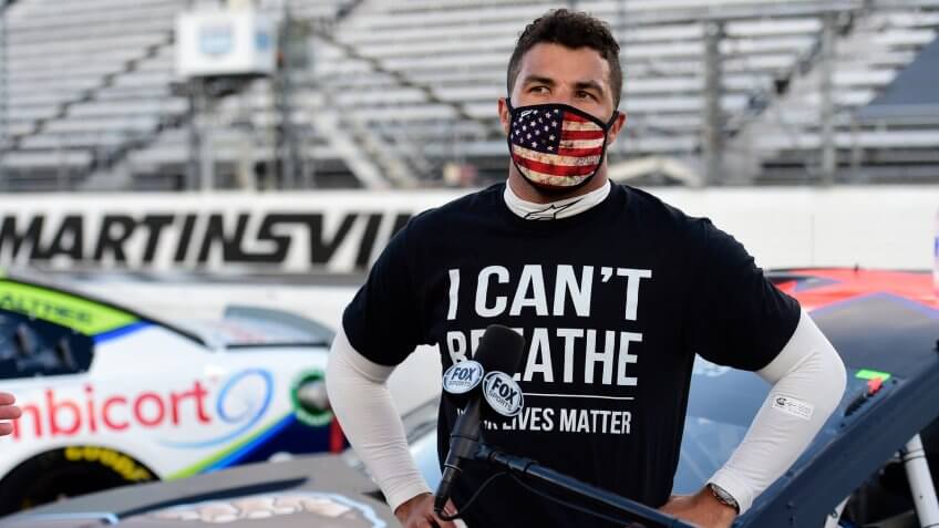 MARTINSVILLE, VIRGINIA - JUNE 10: Bubba Wallace, driver of the #43 Richard Petty Motorsports Chevrolet, wears a "I Can't Breathee - Black Lives Matter" t-shirt under his fire suit in solidarity with protesters around the world taking to the streets after the death of George Floyd on May 25, speaks to the media prior to the NASCAR Cup Series Blue-Emu Maximum Pain Relief 500 at Martinsville Speedway on June 10, 2020 in Martinsville, Virginia.