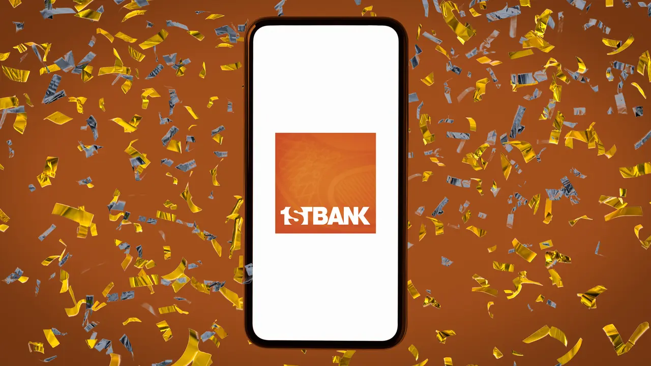 Orange background covered by confetti and a smartphone resting on the top displaying the FirstBank logo