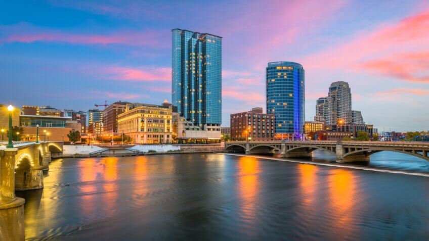 Grand Rapids, Michigan, USA downtown skyline on the Grand River at dusk.