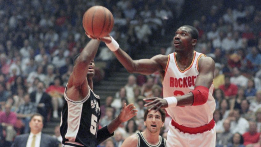 Houston Rockets center Hakeem Olajuwon (34) shoots around San Antonio Spurs center David Robinson as Spurs guard Vinny Del Negro (15) looks on during the first quarter of Game 3 of the Western Conference finals, in HoustonSpurs vs Rockets, Houston, USA.