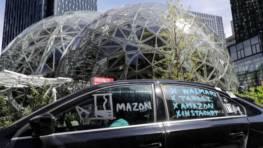 Mandatory Credit: Photo by Ted S Warren/AP/Shutterstock (10631590i)Protester drives a car with writing that calls for a general strike by workers from Walmart, Target, Amazon, and Instacart during a car-based protest, at the Amazon Spheres in downtown Seattle.