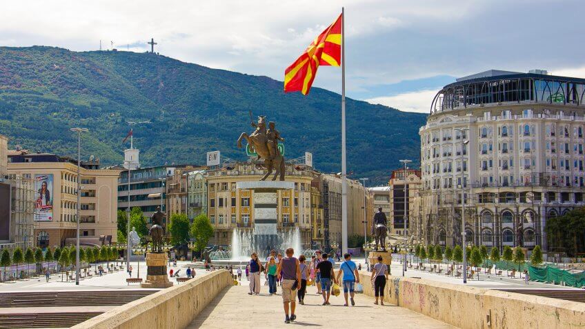Skopje, Republic of Macedonia - September 6, 2015: People on stone bridge and the view of bronze statue of Alexander the Great on a rearing horse holding a sword high up in Skopje city main square, Former Yugoslav Republic of Macedonia (Macedonia FYR).