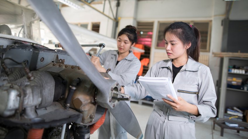 Asian women Engineers and technicians are repairing aircraft.