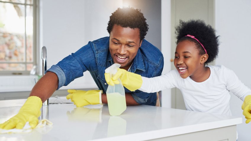 Shot of a little girl and her father enjoying their chores at home.