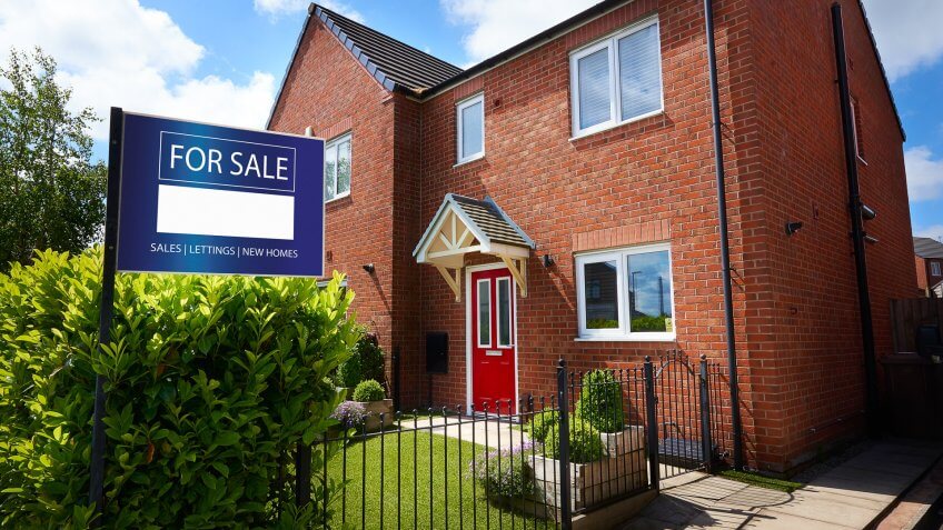 Residential home with For Sale sign out the front.