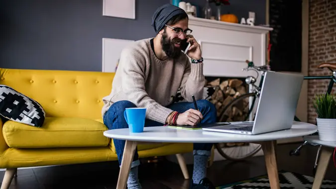 Smiling webdesigner working from his home office.