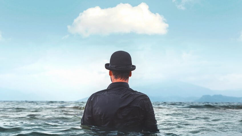 man with hat in water with cloud