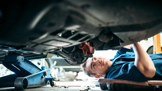 Low angle view of a mechanic working under a vehicle.