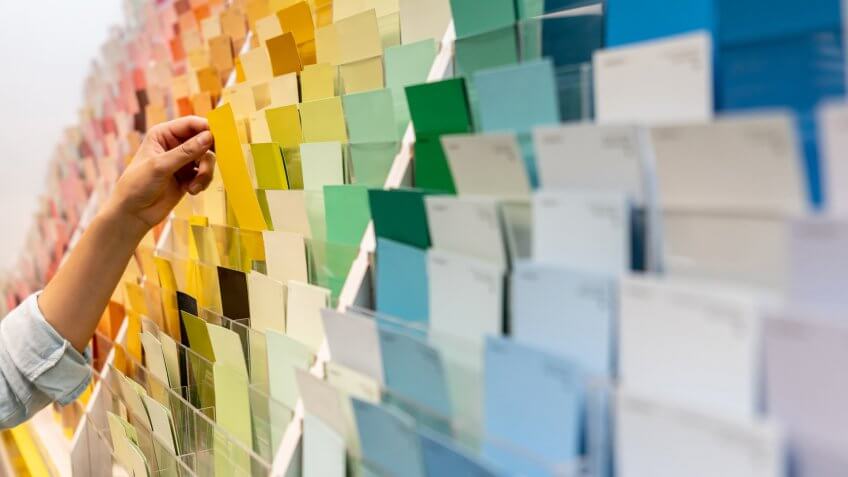 Close-up on a customer holding a color sample at a home improvement store - remodeling and painting concepts.