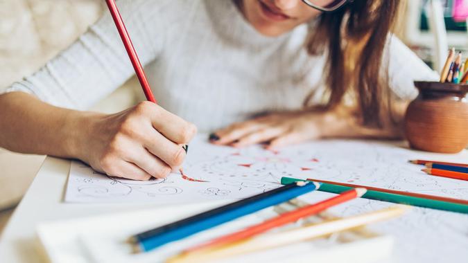 Woman coloring doodle with color pencils for relaxation.