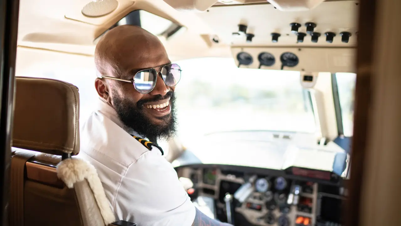 Portrait of airplane pilot looking over shoulder in a private jet.