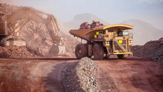 Loading of copper ore on very big dump-body truck.