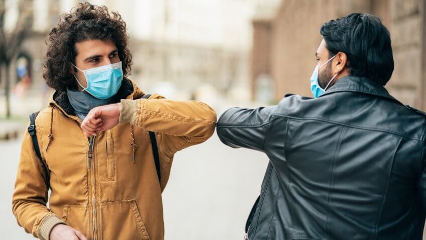 Young people friends meeting in quarantine and greeting without touching their hands.